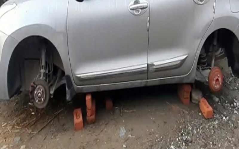 Thieves gang active, clean hands on tires of parked vehicle